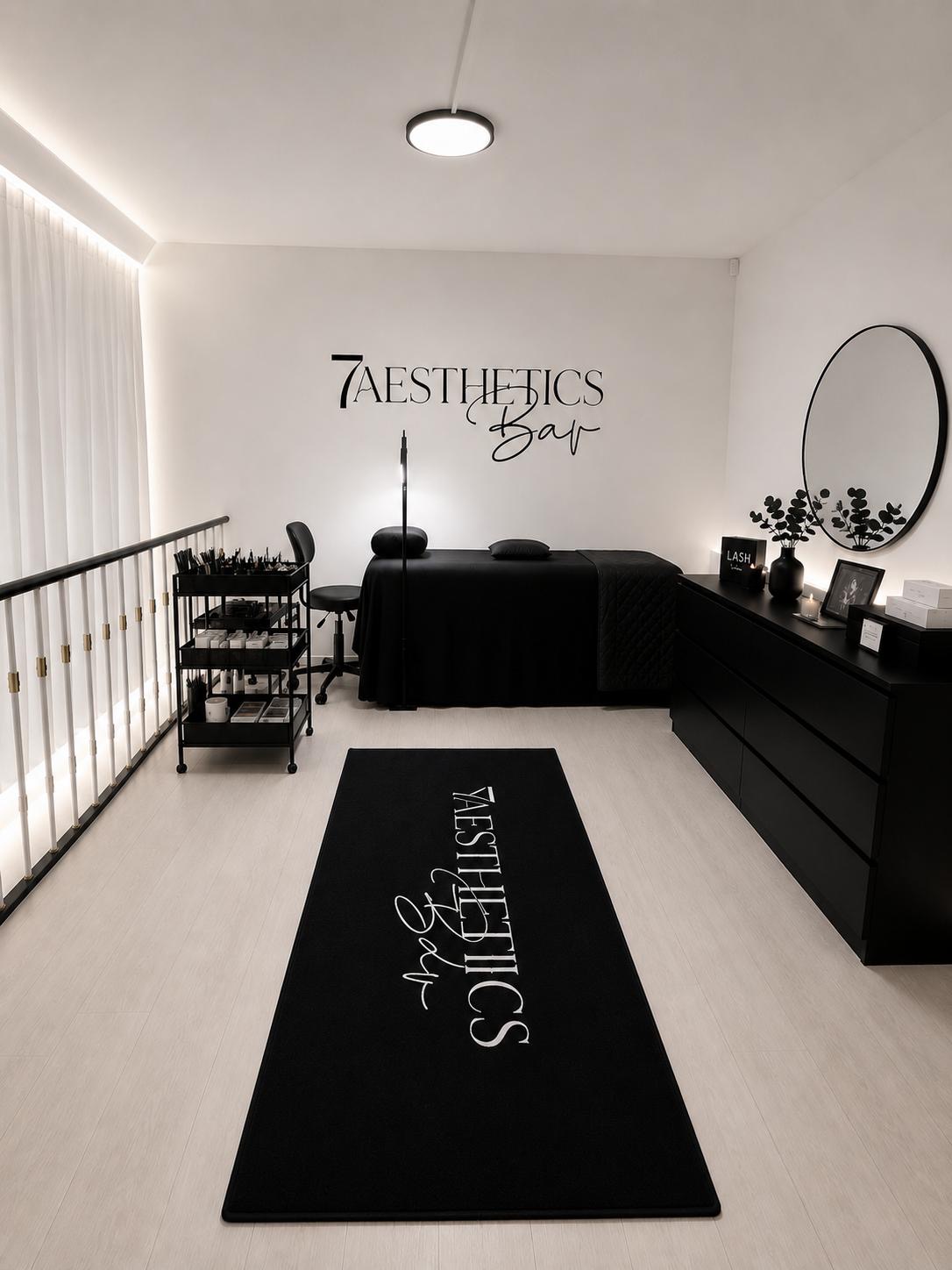 The 7AESTHETICSBAR studio interior, with a black lash bed and the brand runner